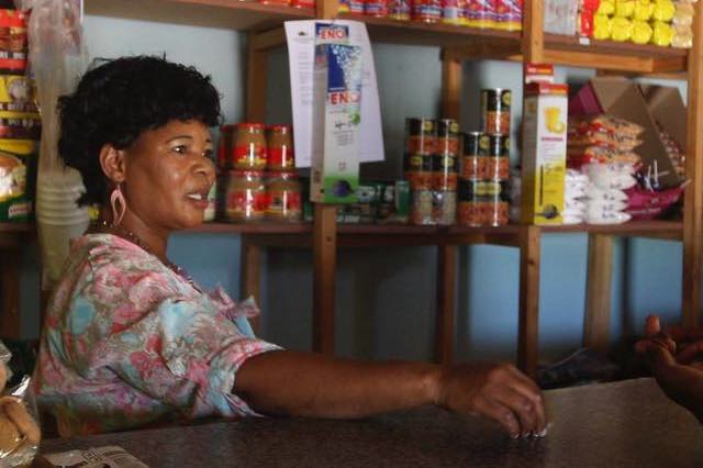 A spaza shop owner sells to a customer: picture by SIMON MATHEBULA